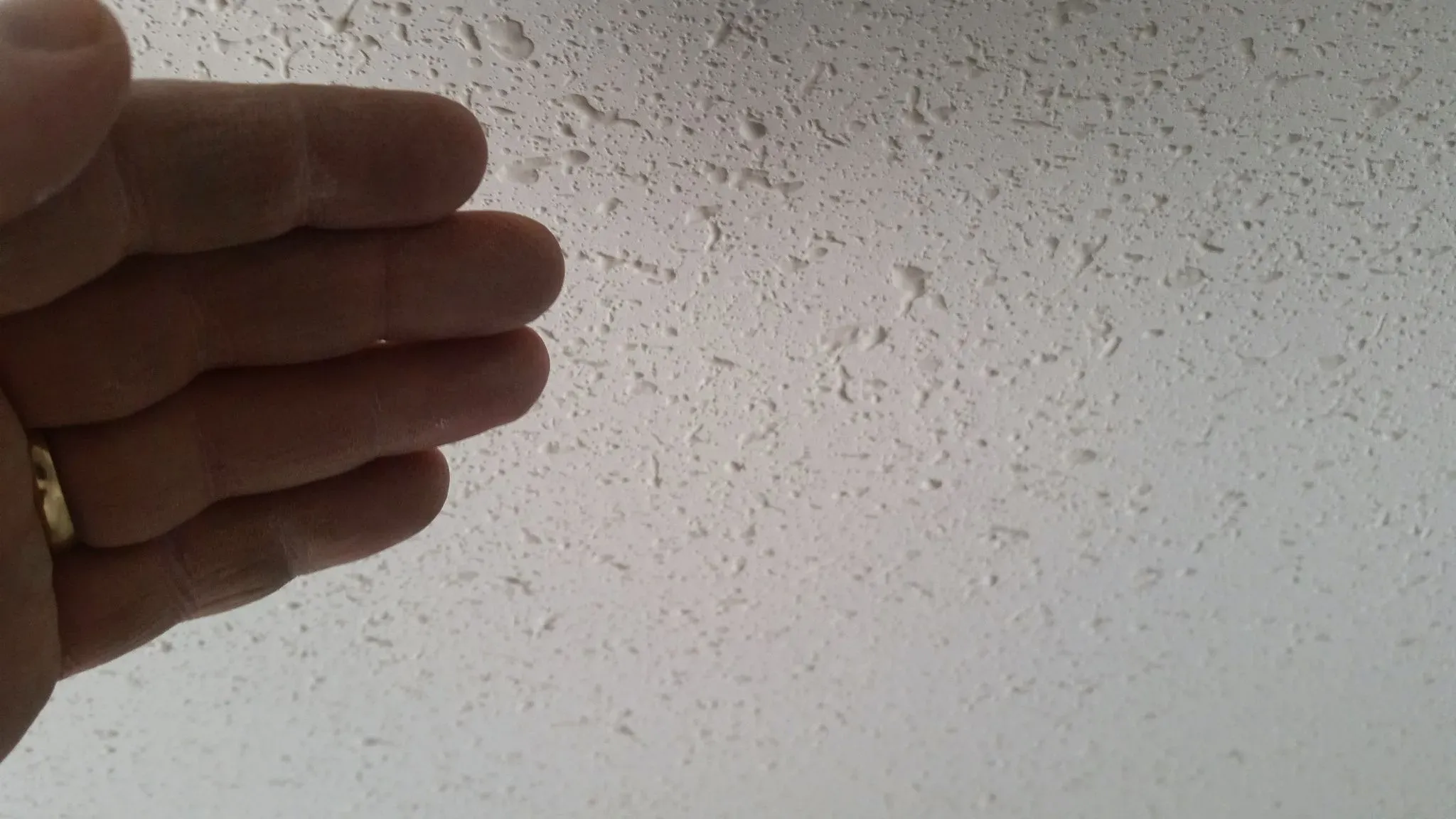 Hand checking the surface of a dried texture finish